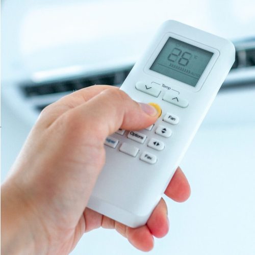 Air conditioner temperature adjustment with remote controller in room at home. Air conditioner temperature adjustment with remote controller in room at home.